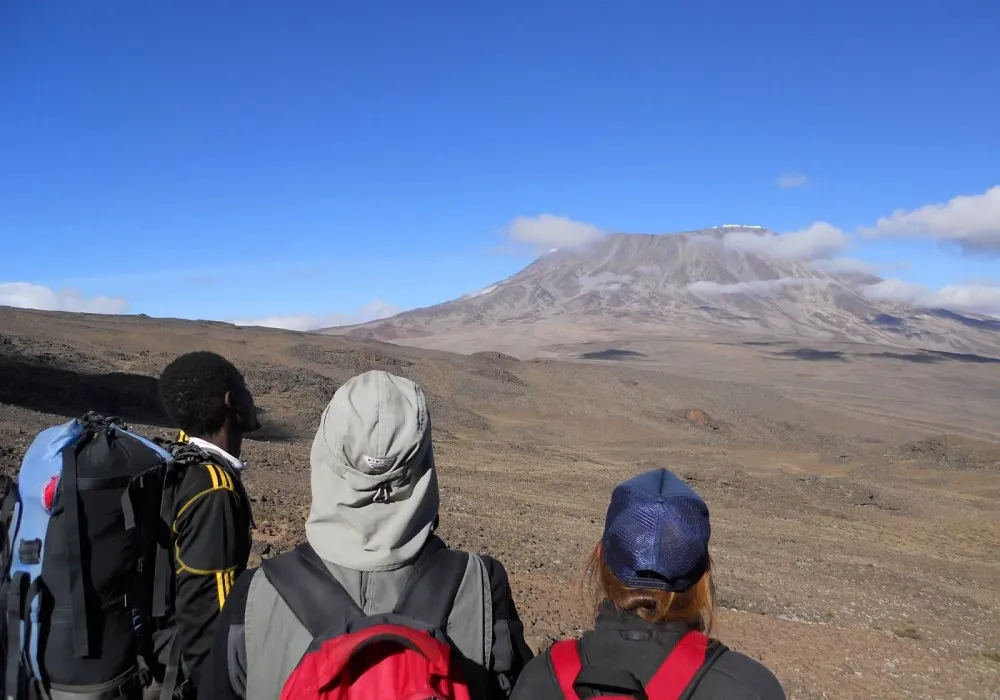 Small group of hikers looking towards Mount Kilimanjaro