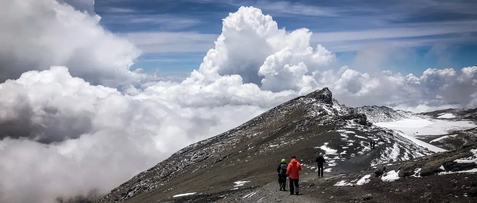 Hikers walking above the clouds on Mount Kilimanjaro