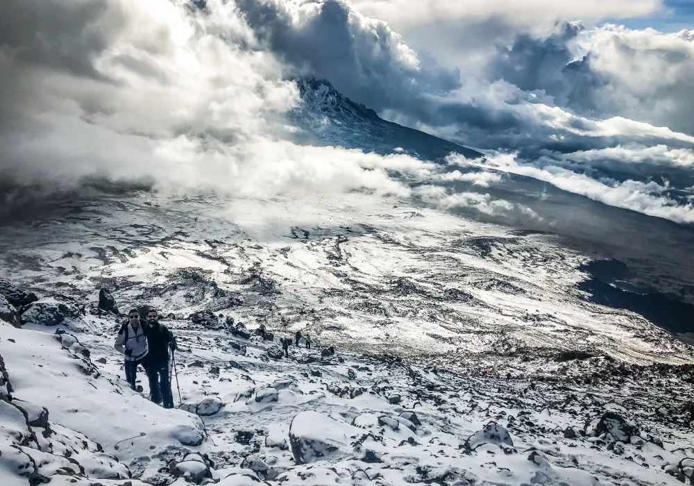 Hikers trekking through snow on Mount Kilimanjaro at high altitude