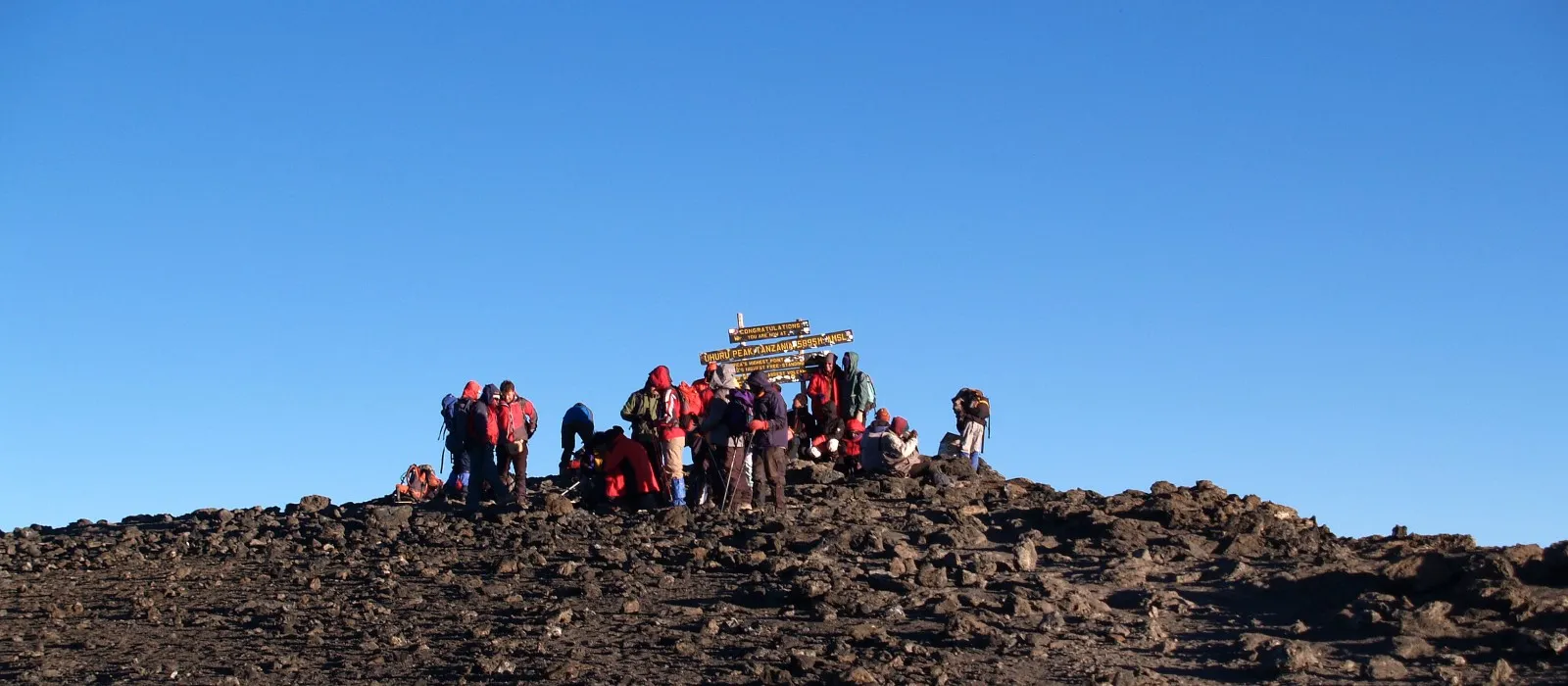 Hikers at Uhuru Peak during clear weather on Mount Kilimanjaro