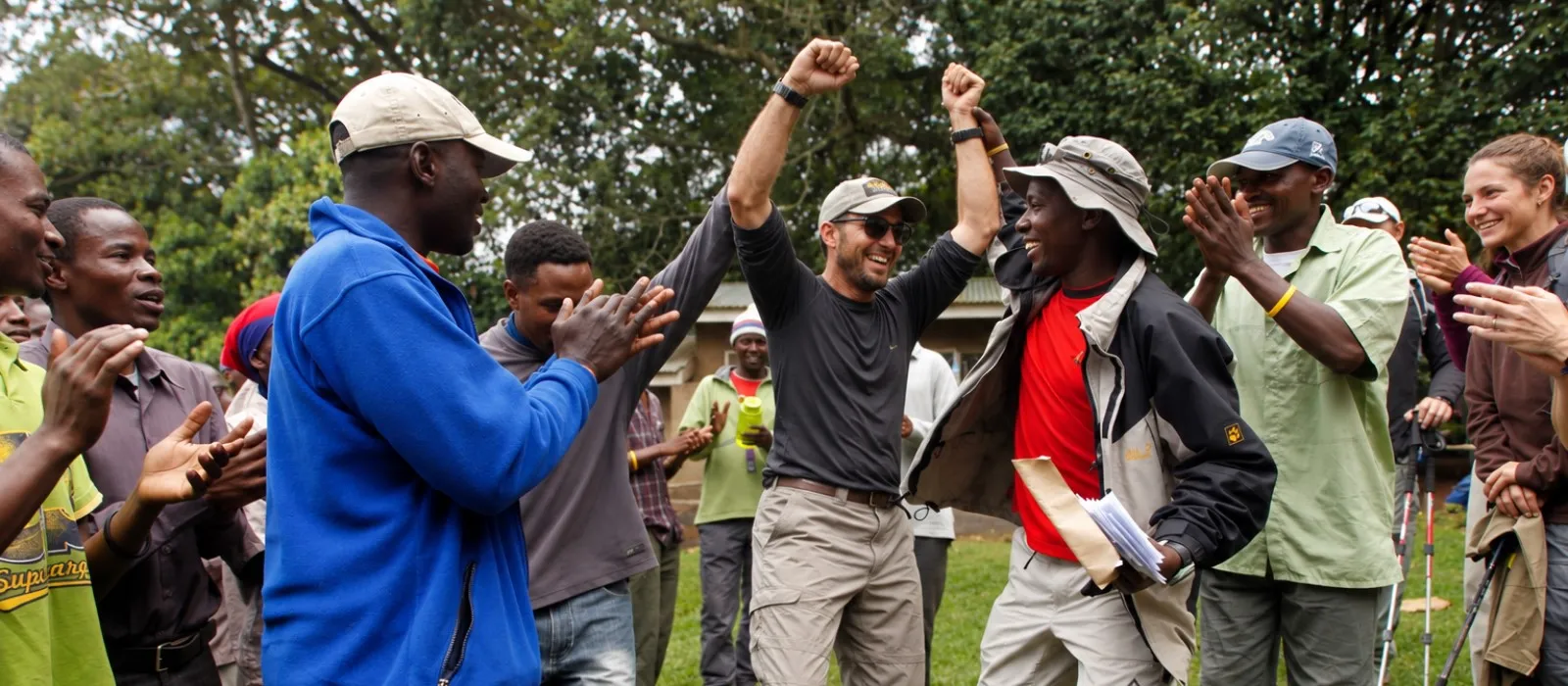 Kilimanjaro hikers and mountain crew celebrating together after the climb
