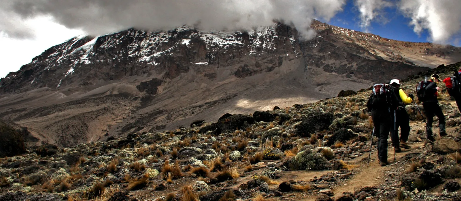 Hikers training for Kilimanjaro by walking uphill on mountain terrain