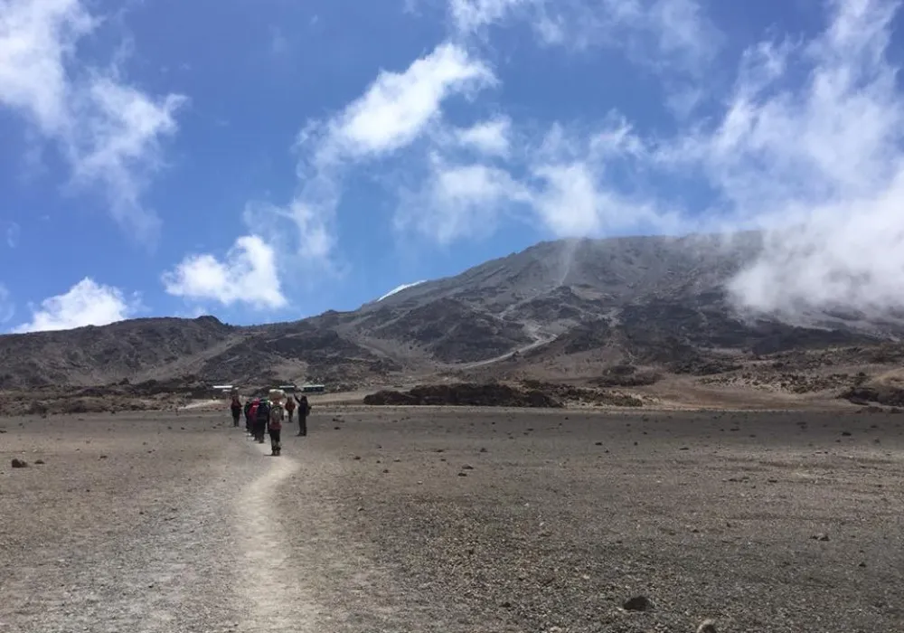 Hikers crossing the high alpine terrain on the Rongai Route towards Kibo Hut