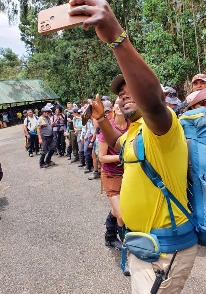 Hikers using a mobile phone while climbing Mount Kilimanjaro