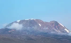 Mount Kilimanjaro rising above the surrounding Tanzanian landscape