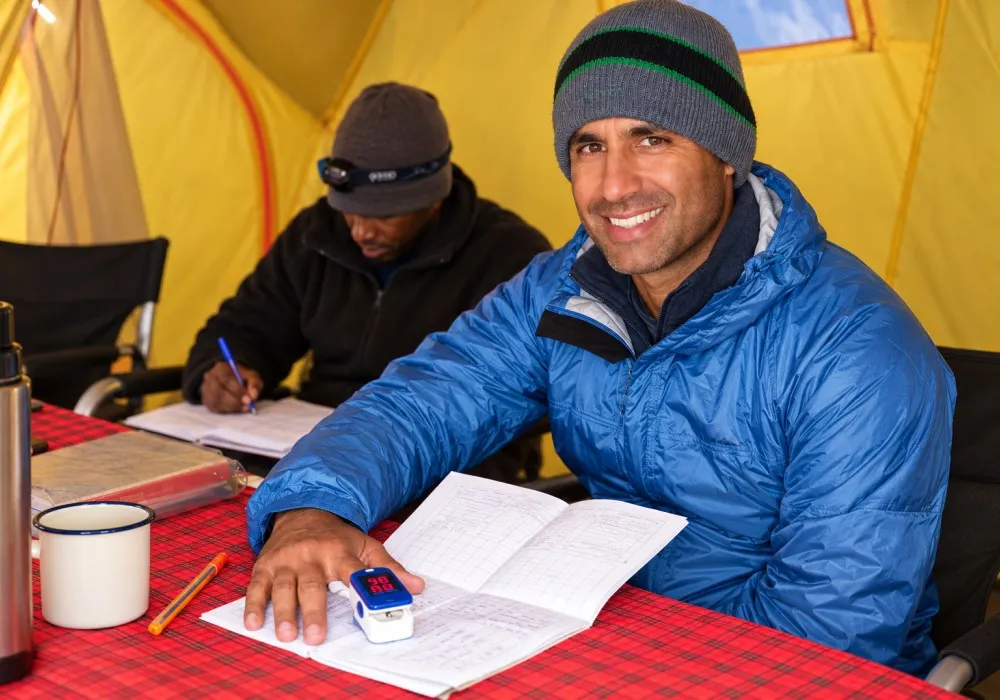 Guide conducting a health check on a hiker during a Kilimanjaro climb
