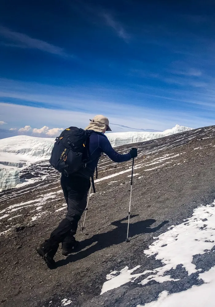 Hiker walking along the crater rim near the summit of Mount Kilimanjaro